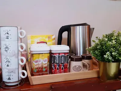 a wooden tray filled with drinks and a coffee pot at Baan U-Sabai บ้านอยู่สบาย in Bangkok