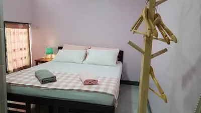 a bedroom with a bed with two towels on it at Baan U-Sabai บ้านอยู่สบาย in Bangkok