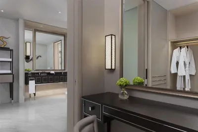 a bathroom with a mirror and a dressing room at Sindhorn Kempinski Hotel Bangkok in Bangkok