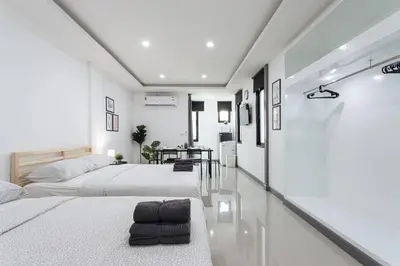 two beds in a room with white walls at P4 Silom Large 2beds full kitchen WIFI 4-6pax in Bangkok