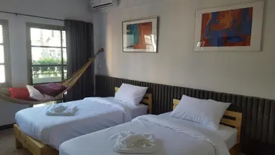 a hotel room with two beds and a hammock at Haus Sathorn 11 Residence in Bangkok