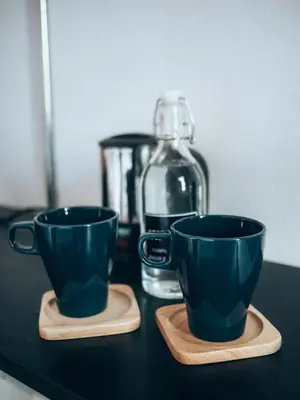 two green cups on a counter with a blender at Haus Sathorn 11 Residence in Bangkok