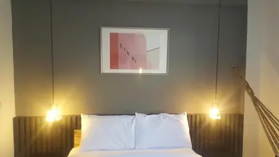 a bedroom with a bed with two lights above it at Haus Sathorn 11 Residence in Bangkok