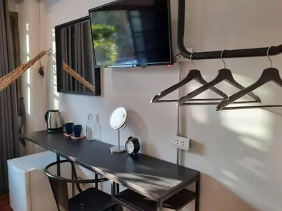 a desk in a room with a television on a wall at Haus Sathorn 11 Residence in Bangkok