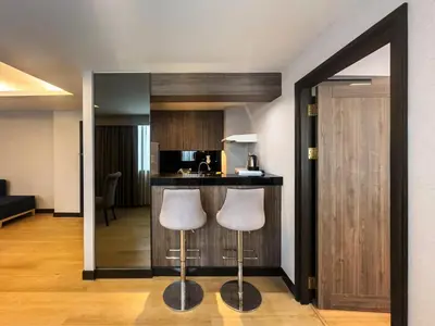 a kitchen with two stools and a bar in a room at Rembrandt Residences Bangkok in Bangkok