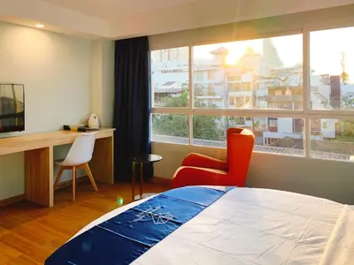 a bedroom with a bed and a desk and a window at Sapphire Hotel Silom Bangkok in Bangkok