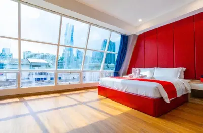 a bedroom with a red headboard and large windows at Sapphire Hotel Silom Bangkok in Bangkok