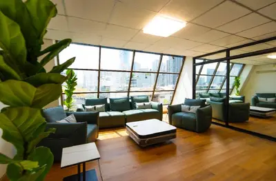 a living room with couches and a coffee table at Sapphire Hotel Silom Bangkok in Bangkok