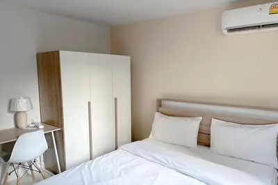 a bedroom with a white bed and a white cabinet at Cordia Residence Sathorn in Bang Rak