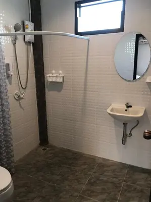 a bathroom with a sink and a mirror and a shower at BAANYA HOMESTAY Ko Kret in Nonthaburi