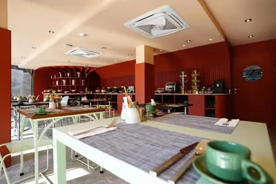 a restaurant with red walls and tables and chairs at 4 Monkeys Hotel in Bangkok