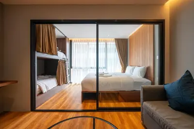 a mirror in a room with a bed and a couch at Woodstory Boutique Hotel in Bangkok