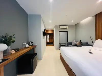 a hotel room with a bed and a couch at Woodstory Boutique Hotel in Bangkok