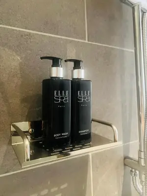 two bottles of soap sitting on a shelf in a bathroom at Woodstory Boutique Hotel in Bangkok