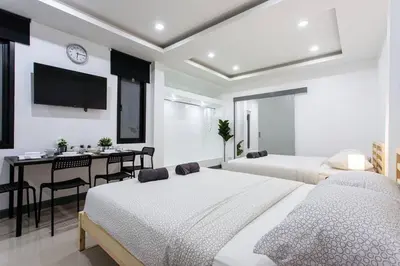 a bedroom with two beds and a table and a tv at P2 Silom Large 2beds full kitchen WIFI 4-6pax in Bangkok