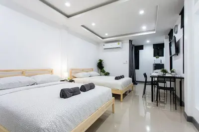 a bedroom with two beds and a table with a desk at P2 Silom Large 2beds full kitchen WIFI 4-6pax in Bangkok