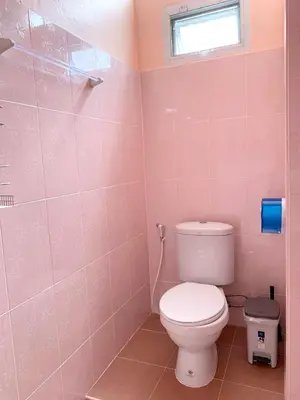 a pink bathroom with a toilet and a window at Gaiwandhanat Homestay in Bangkok