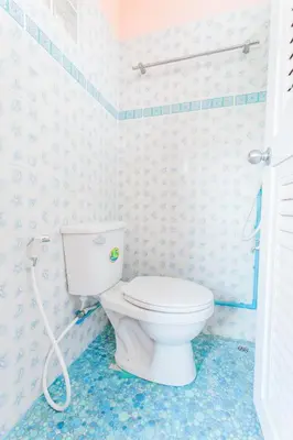 a bathroom with a white toilet in a room at Gaiwandhanat Homestay in Bangkok