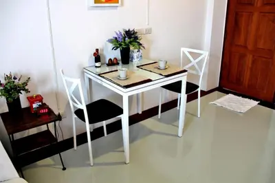 a white table and chairs in a room at The Meet Green Apartment in Bangkok