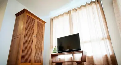 a flat screen tv sitting in front of a window at The Meet Green Apartment in Bangkok