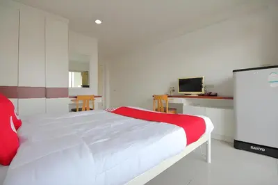 a bedroom with a white bed and a tv at Super OYO 498 Ladawan Villa in Bangkok