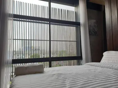 a bedroom with a bed and a large window at The LOCAL Ari in Bangkok