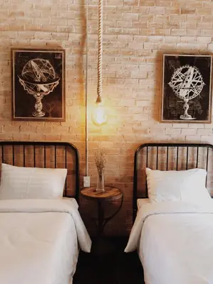 two beds in a room with a brick wall at The LOCAL Ari in Bangkok