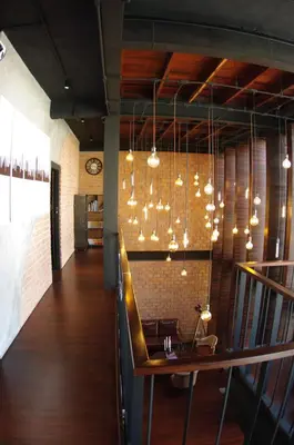 a dining room with a table and chandelier at The LOCAL Ari in Bangkok