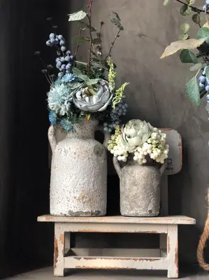 two large vases sitting on a table with flowers at The LOCAL Ari in Bangkok