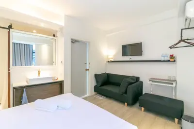 a bedroom with a bed and a green couch at UHU Bangkok in Bangkok