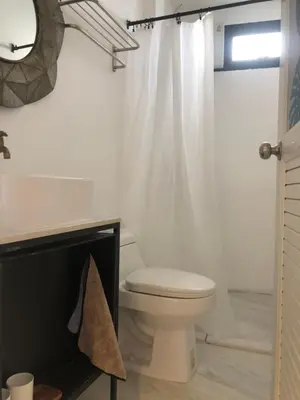 a white bathroom with a toilet and a shower at UHU Bangkok in Bangkok
