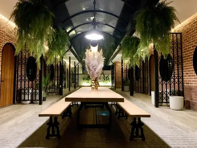 a table in a room with two benches and plants at The Matta in Bangkok