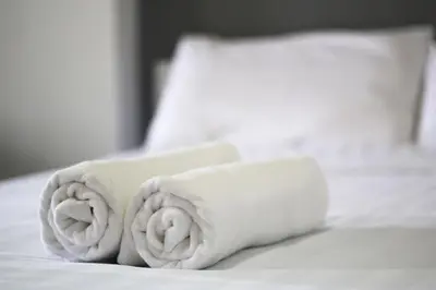 a stack of towels on a bed at Sakun Place in Bangna
