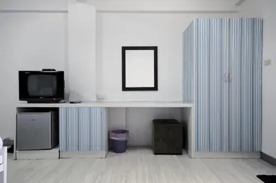 a living room with a tv and a desk with a mirror at Sakun Place in Bangna