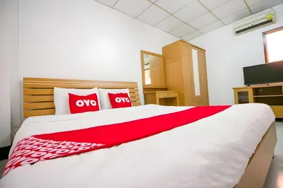 a bedroom with a large white bed with two red pillows at OYO 525 MRT Phetkasem 48 -1 Place in Bangkok