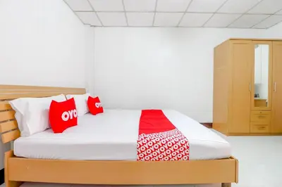 a bedroom with a bed with red and white pillows at OYO 525 MRT Phetkasem 48 -1 Place in Bangkok