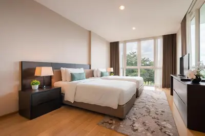 a bedroom with a large bed and a television at North Park Serviced Apartment Bangkok in Bangkok