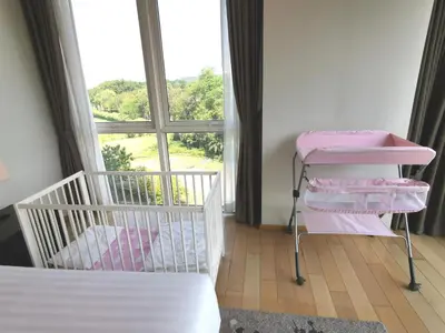 a bedroom with a bed and a window and a bed and towels at North Park Serviced Apartment Bangkok in Bangkok
