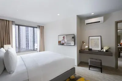 a bedroom with a white bed and a window at Somerset Rama 9 Bangkok in Bangkok