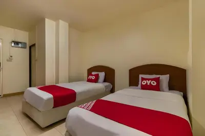 two beds in a room with red and white pillows at OYO 583 Sweethome Guest House in Bangkok Noi