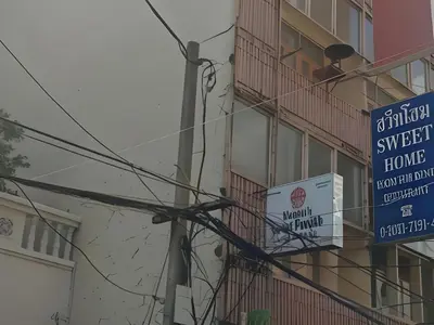 a building with signs on the side of it at OYO 583 Sweethome Guest House in Bangkok Noi