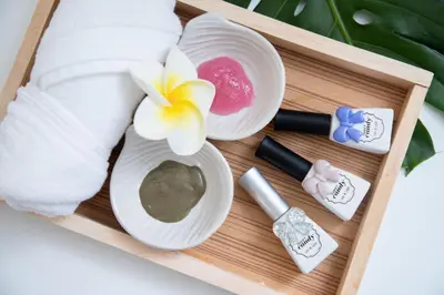 a wooden tray with towels and a flower and cosmetics at J & L Residence and Spa in Ban Khlong Khwang Klang