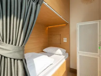a bedroom with a bed with a curtain at Ratchada Hotel - ROTFAI in Bangkok