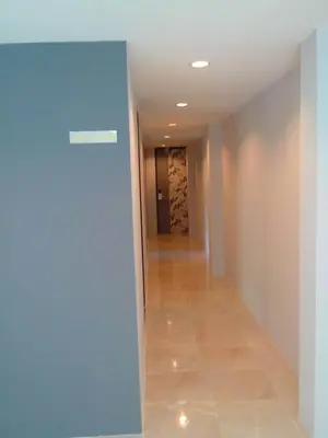 a hallway with a blue wall and a tile floor at Nantra Ploenchit hotel in Bangkok