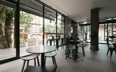 a restaurant with tables and chairs and large windows at 56 Hotel in Bangna
