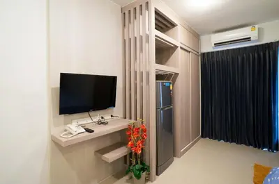 a room with a television and a vase of flowers at DB PLUS 6 in Bangkok