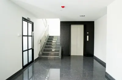 a hallway with stairs and a door in a building at DB PLUS 6 in Bangkok