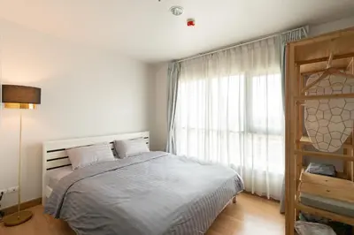 a bedroom with a bed and a large window at Ekkamai+Thong Lor in Bangkok