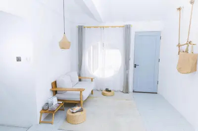 a white living room with a chair and a door at Ratchada Retreat Boutique Villa 1 in Bangkok