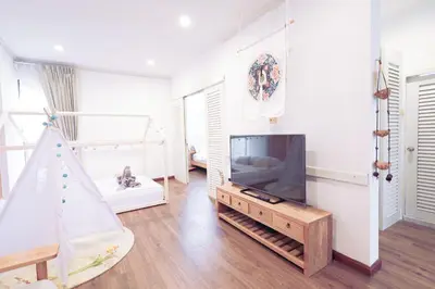 a living room with a television and a christmas tree at Ratchada Retreat Boutique Villa 1 in Bangkok